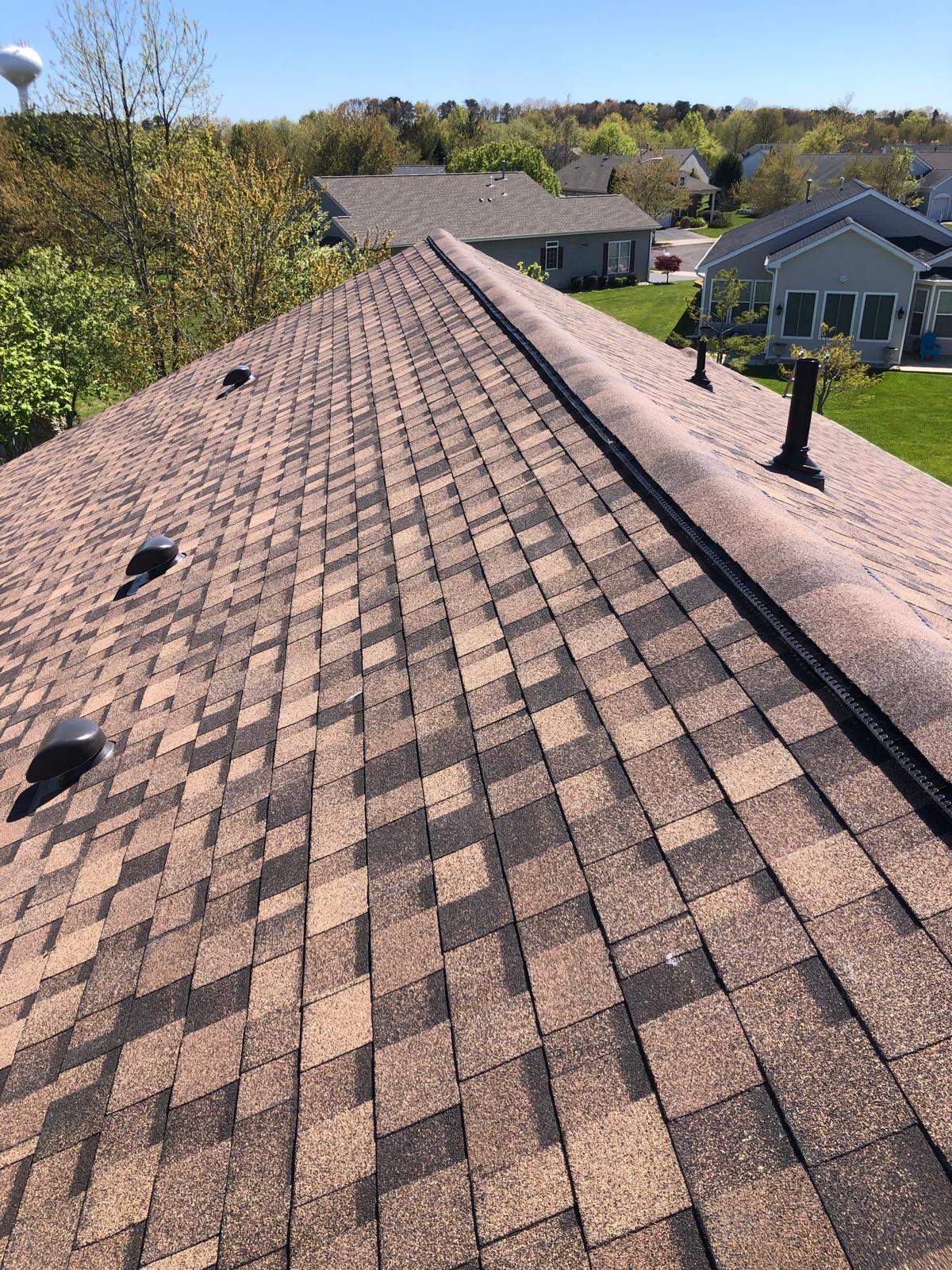 Roofing installation featuring quality asphalt shingles, showcasing a well-maintained roof in a residential area near Galloway, NJ, with clear blue skies and surrounding greenery.