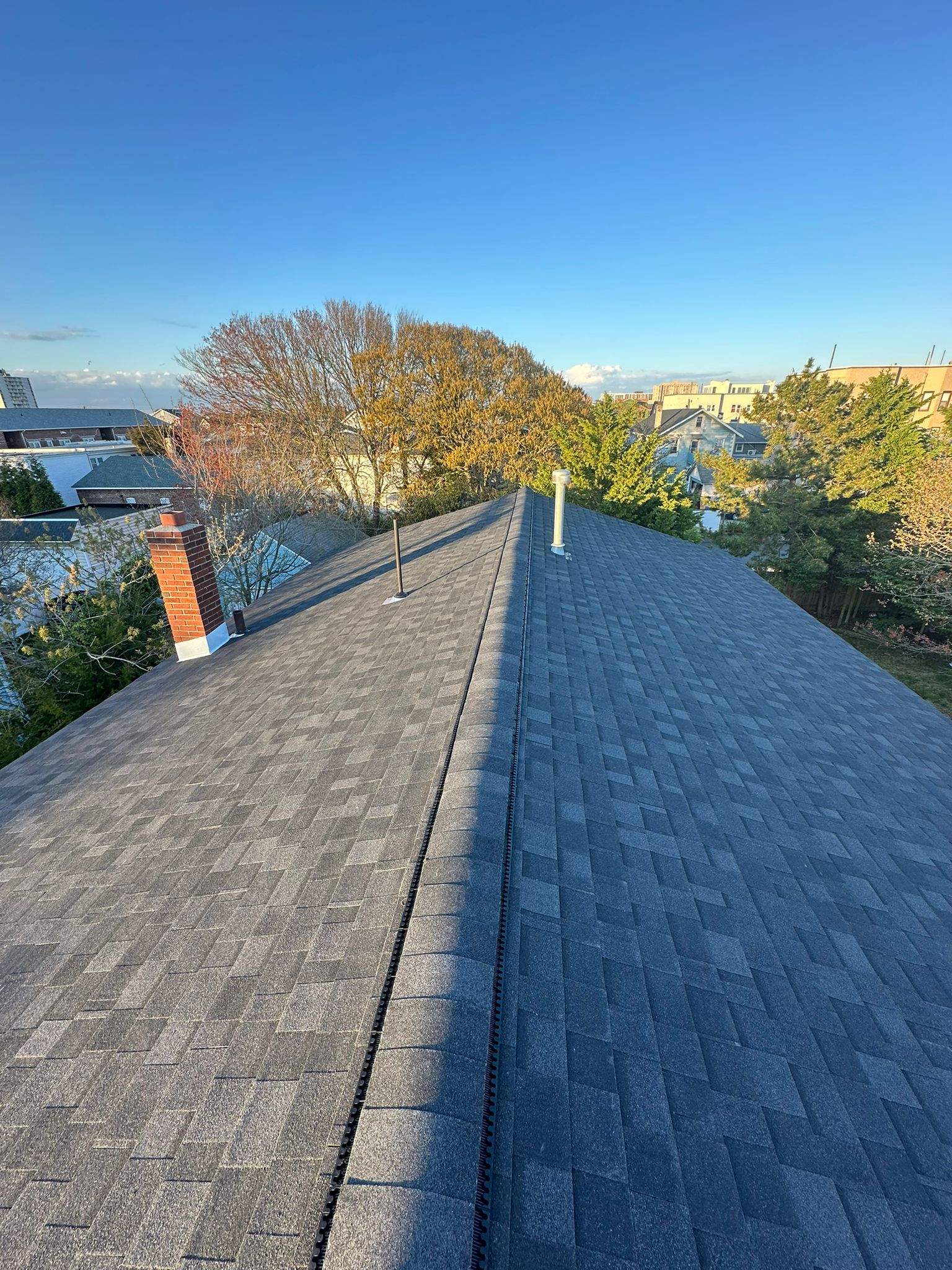 Roof view showcasing asphalt shingles and chimney, highlighting quality roofing in Ventnor City, NJ.